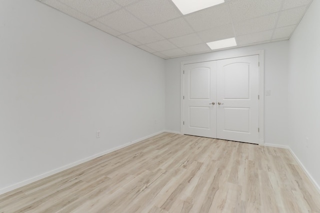 15054 E 2500 N Rd, Hudson, IL 61748 - unfurnished bedroom with light wood finished floors, a drop ceiling, baseboards, and a closet