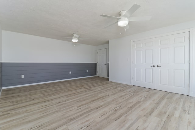 unfurnished bedroom with a closet, ceiling fan, a textured ceiling, and light hardwood / wood-style flooring