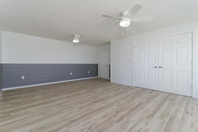 15054 E 2500 N Rd, Hudson, IL 61748 - unfurnished bedroom featuring light wood-style floors, a textured ceiling, a ceiling fan, and baseboards