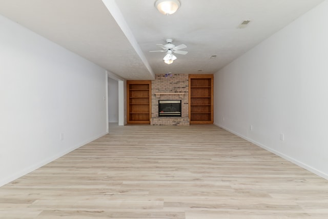 unfurnished living room featuring light hardwood / wood-style floors, a fireplace, and ceiling fan