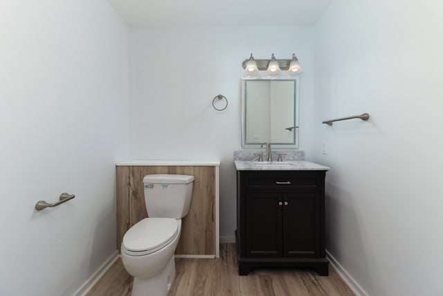 bathroom with vanity, wood-type flooring, and toilet