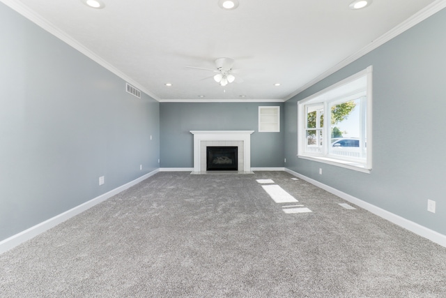 unfurnished living room featuring ornamental molding, a tiled fireplace, carpet, and ceiling fan