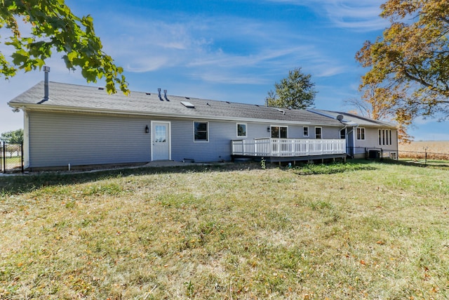 back of property featuring a wooden deck and a lawn