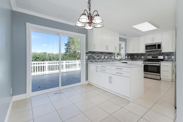 kitchen with stainless steel appliances, crown molding, pendant lighting, white cabinets, and tasteful backsplash