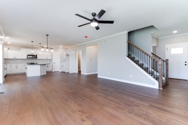 unfurnished living room featuring hardwood / wood-style flooring, ceiling fan, and ornamental molding