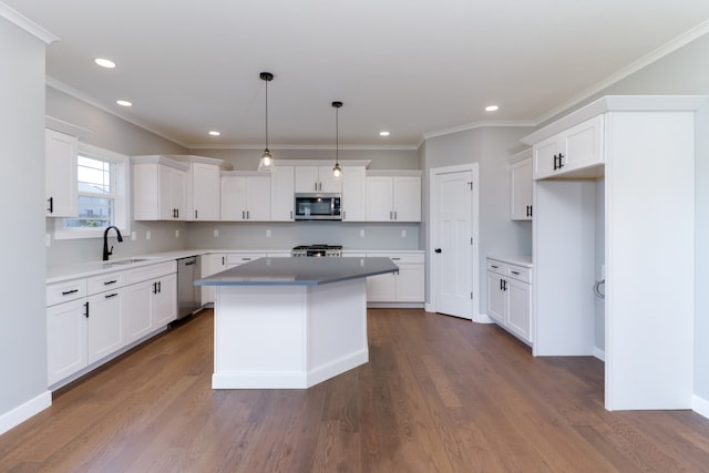 kitchen featuring white cabinetry, hanging light fixtures, dark hardwood / wood-style floors, a kitchen island, and appliances with stainless steel finishes