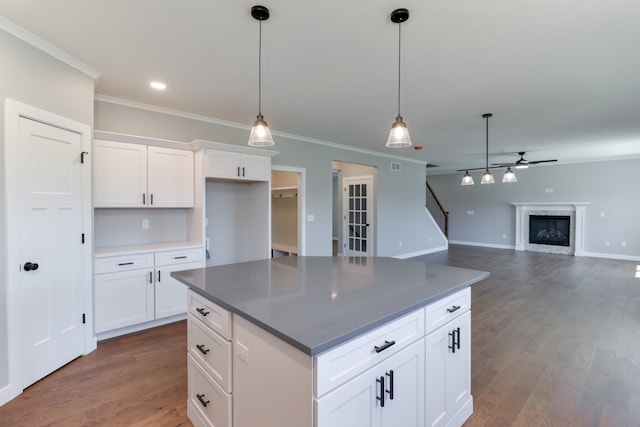 kitchen with white cabinets, pendant lighting, dark hardwood / wood-style flooring, and crown molding