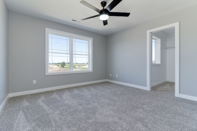 unfurnished room with ceiling fan and carpet floors