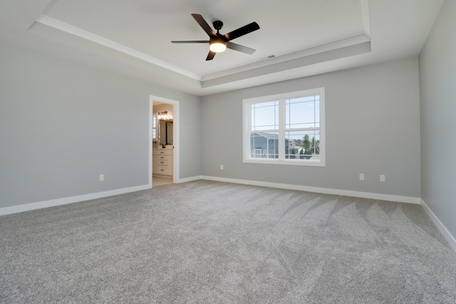 spare room featuring ceiling fan, carpet floors, and a tray ceiling