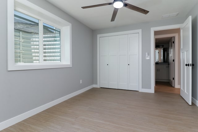 unfurnished bedroom featuring a closet, light hardwood / wood-style floors, and ceiling fan