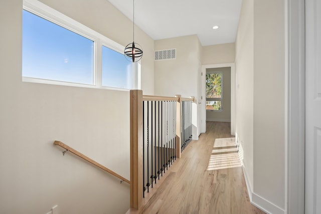 hallway featuring a chandelier and light hardwood / wood-style floors