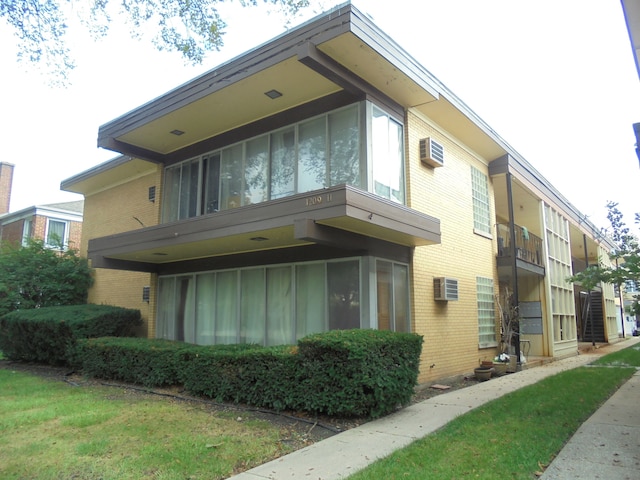 view of side of property featuring an AC wall unit and a balcony