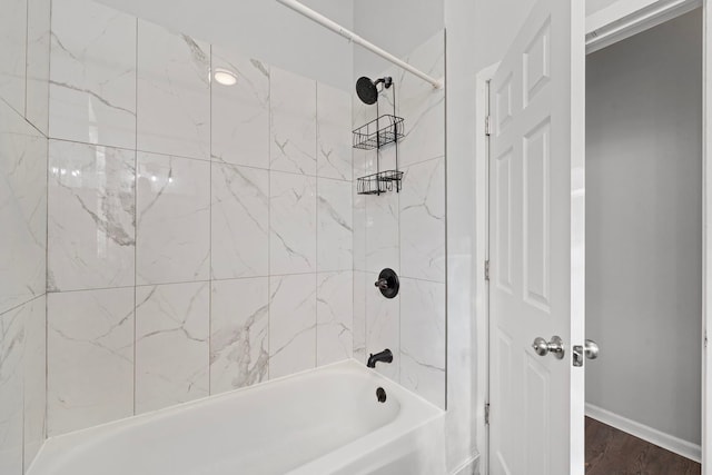 bathroom with hardwood / wood-style floors and tiled shower / bath