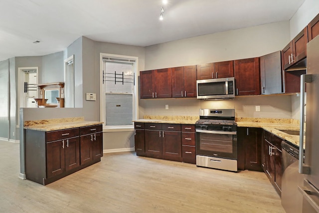 kitchen featuring light hardwood / wood-style flooring, light stone countertops, and stainless steel appliances