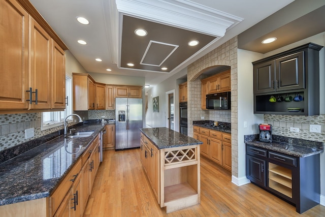 kitchen featuring black appliances, a kitchen island, dark stone countertops, and light hardwood / wood-style floors