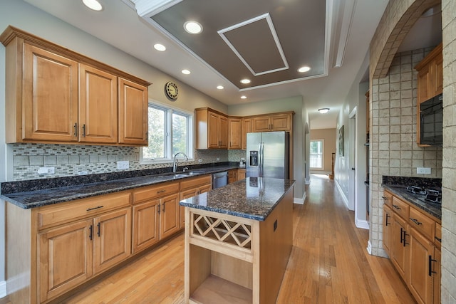 kitchen featuring stainless steel appliances, tasteful backsplash, light hardwood / wood-style floors, and a kitchen island