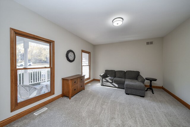 living area featuring a wealth of natural light and light carpet