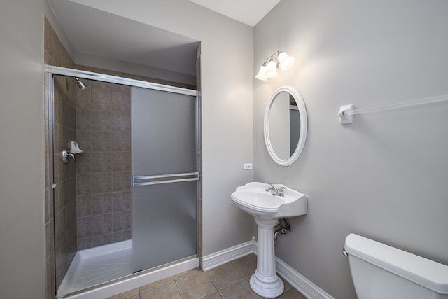 bathroom featuring tile patterned floors, toilet, and an enclosed shower