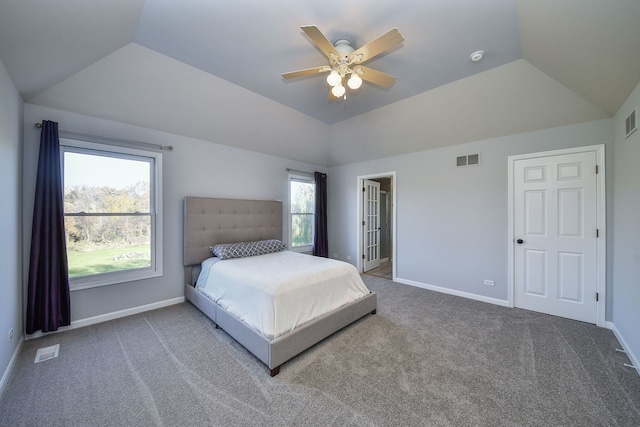 carpeted bedroom with multiple windows, ceiling fan, and vaulted ceiling