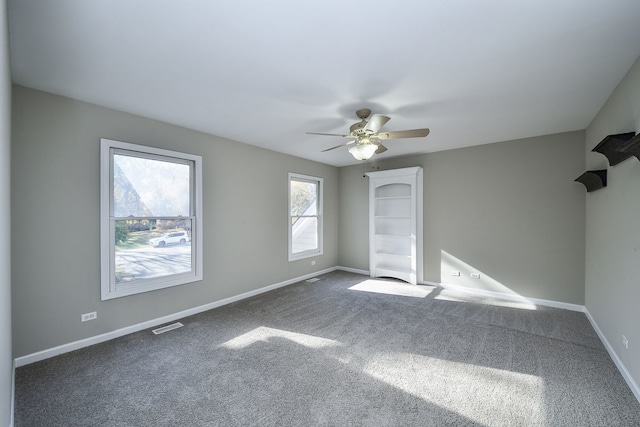 carpeted spare room with ceiling fan