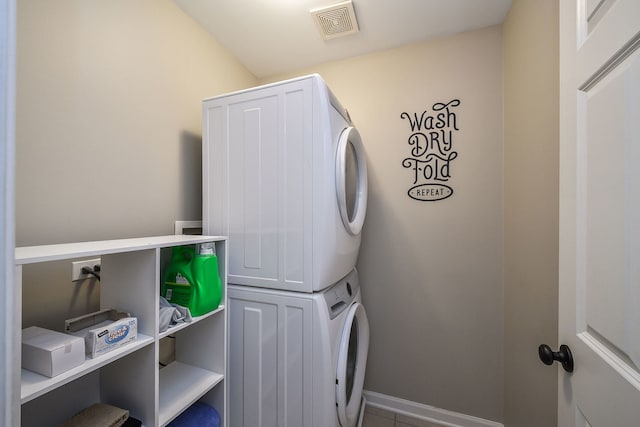 washroom with stacked washer and clothes dryer and tile patterned floors