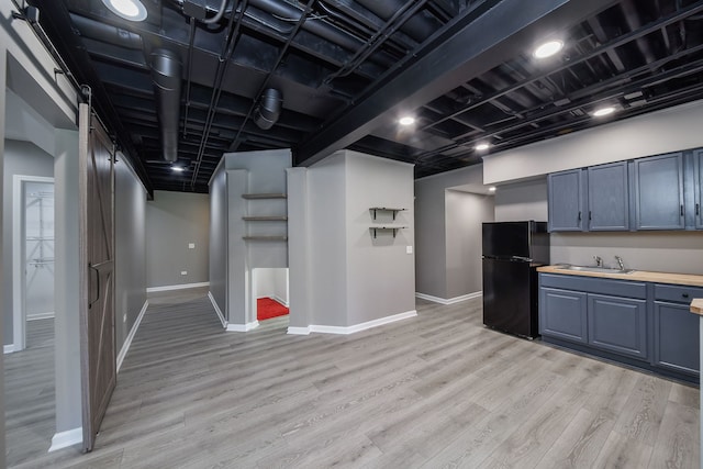 kitchen featuring black refrigerator, sink, wood counters, and light hardwood / wood-style flooring