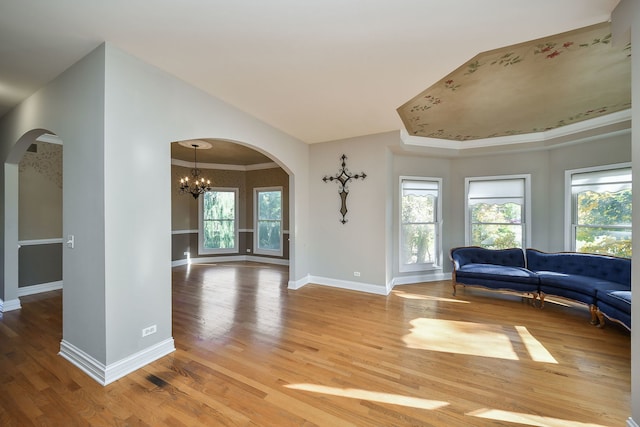 living room with a chandelier, wood-type flooring, and crown molding