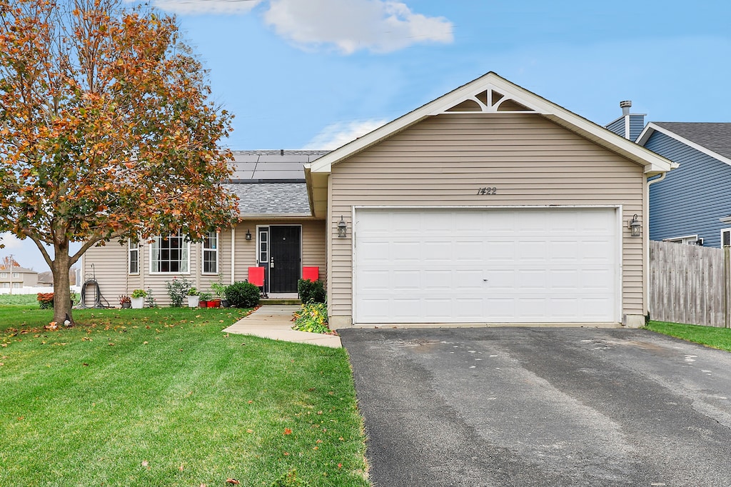 single story home featuring a front lawn and a garage