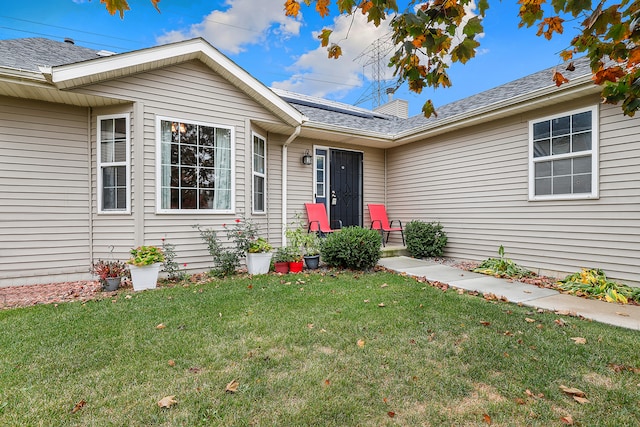 entrance to property with a lawn