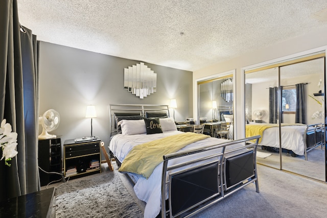 bedroom with multiple closets, carpet, and a textured ceiling