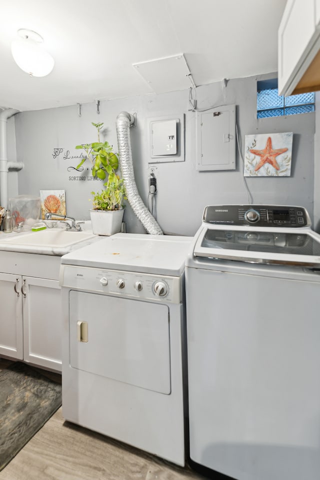 washroom featuring cabinets, light wood-type flooring, washer and dryer, and sink