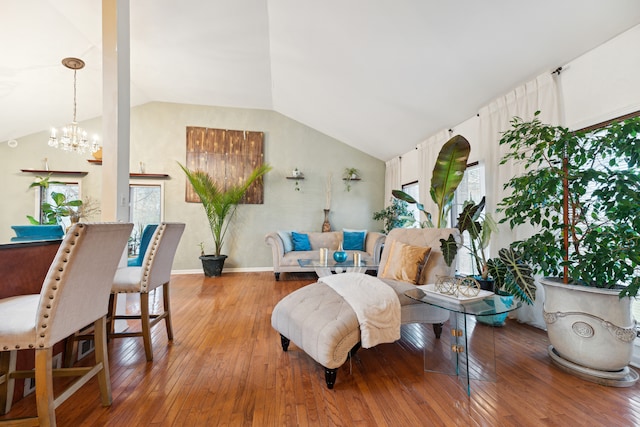 living room with a chandelier, light wood-type flooring, plenty of natural light, and lofted ceiling