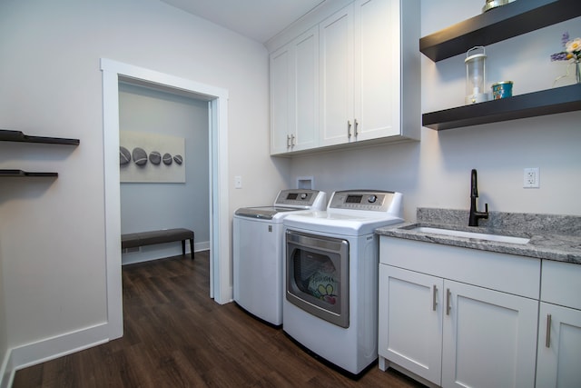 laundry room featuring dark wood-type flooring, washer and dryer, cabinets, and sink