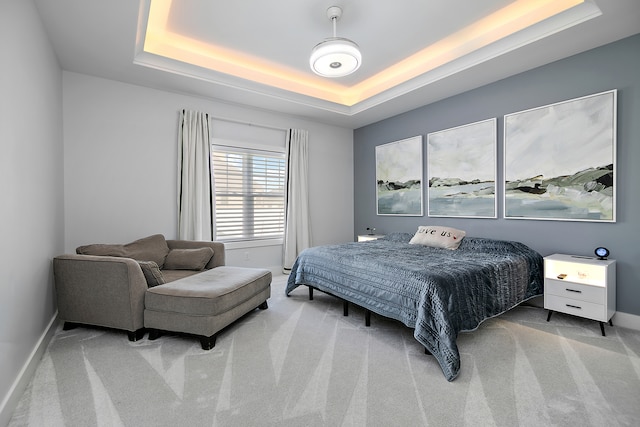 bedroom with carpet and a raised ceiling