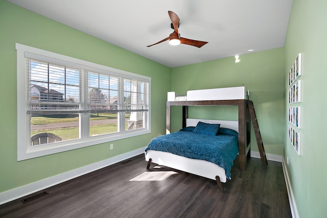 bedroom with multiple windows, dark hardwood / wood-style floors, and ceiling fan