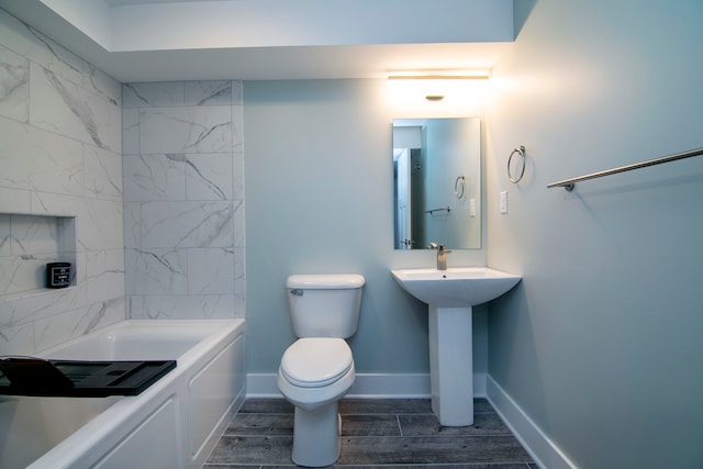 full bathroom with toilet, hardwood / wood-style floors, tiled shower / bath combo, and sink