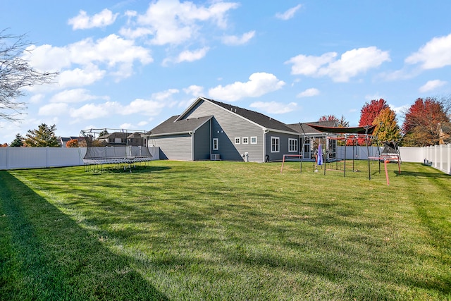 view of yard featuring a garage, a trampoline, and a playground