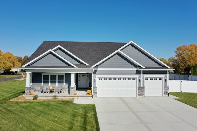 craftsman-style house featuring a front yard, a garage, and covered porch