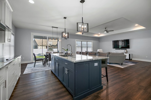 kitchen featuring sink, white cabinetry, decorative light fixtures, and dark hardwood / wood-style flooring