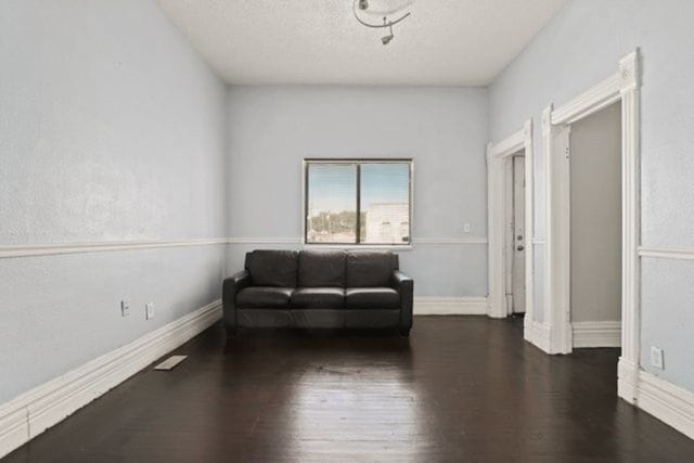 sitting room featuring a textured ceiling and dark hardwood / wood-style flooring