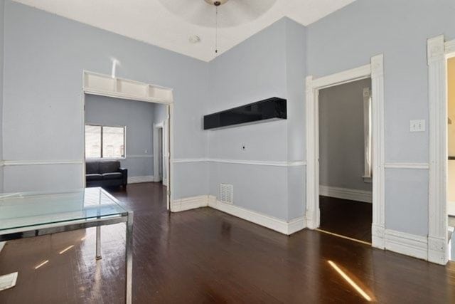 interior space featuring dark wood-type flooring and ceiling fan