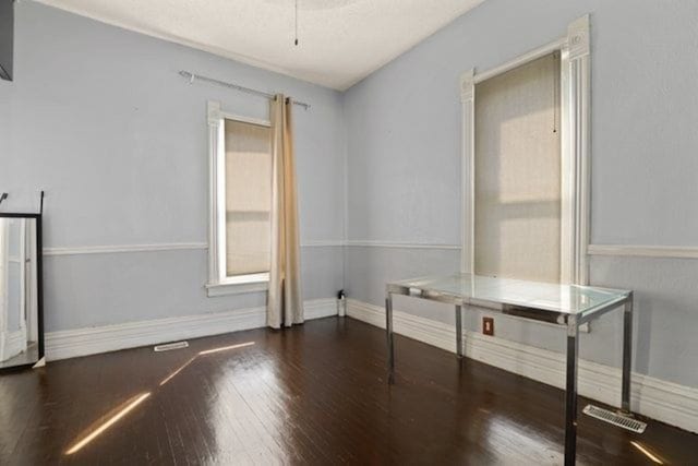 spare room featuring dark wood-type flooring and ceiling fan