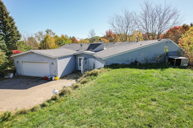 rear view of property featuring a yard and a garage