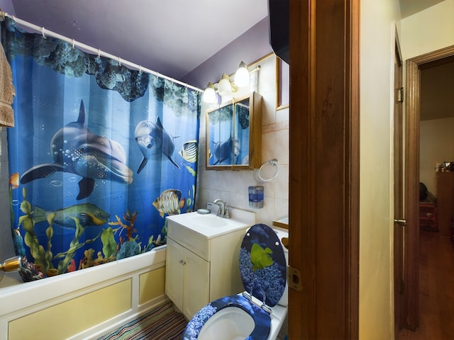 full bathroom featuring toilet, hardwood / wood-style floors, tasteful backsplash, vanity, and shower / bathtub combination with curtain