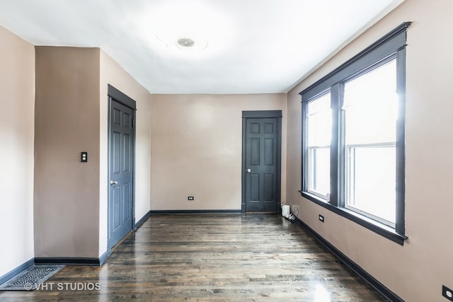 empty room with dark hardwood / wood-style flooring