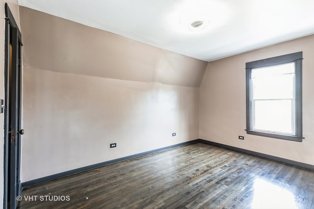 bonus room with lofted ceiling and dark hardwood / wood-style floors