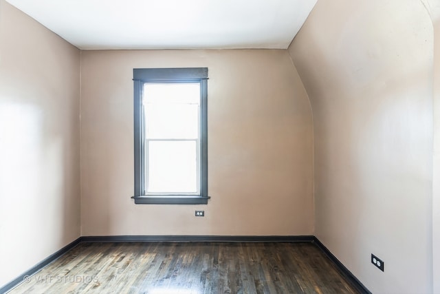 empty room with lofted ceiling and dark wood-type flooring