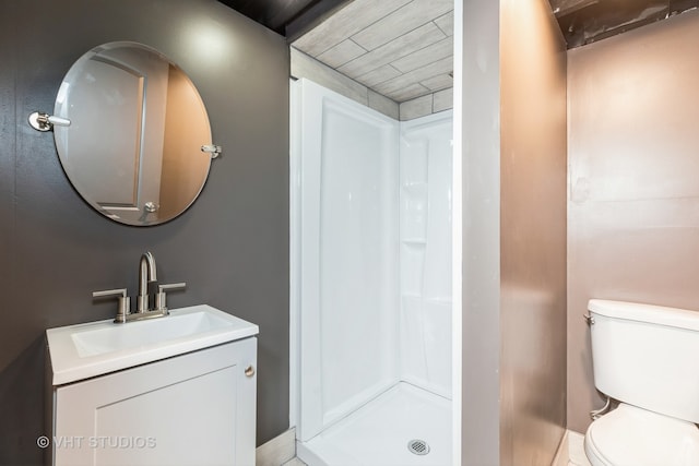 bathroom with vanity, a shower, and toilet