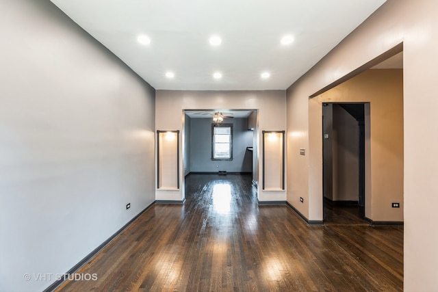 unfurnished living room with dark hardwood / wood-style floors and ceiling fan