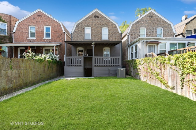 rear view of property featuring covered porch, a lawn, and central AC unit